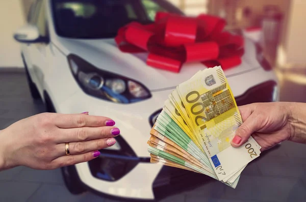 the customer pays euro banknotes for his dream - a new car.