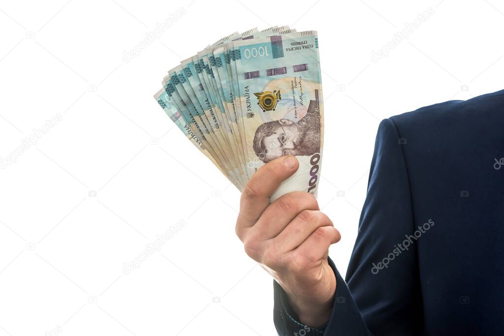businessman made huge profits, showing a lot of money. a man in a suit holds a pack of new banktons of Ukraine. 1000 hryvnia