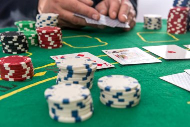 Kumarhane masasında erkek el ele poker fişleri ve kartları. Oyun işi, başarı kavramı