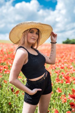 Çiçek tarlasında hasır şapkalı güzel Ukraynalı kadın, seksi, güneşli bir gün.