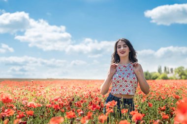 Haşhaş tarlasında güzel bir genç kız. Boş zamanlarını ve güzel havayı eğlenmek için harcıyor.