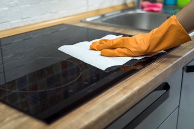  Kadın el temizliği sünger ve deterjan ile modern cam elektrikli hob.