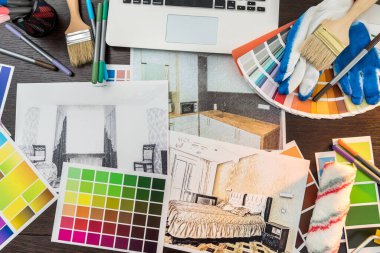 Ofis masasında renk örneği ve fırça eşkali var. İşyeri Mimarı. Yenileme evi çiziliyor.  