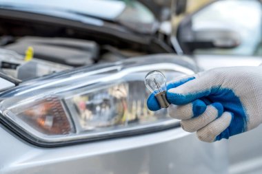 Profesyonel işçi yeni halojen ampullerin arabasını değiştiriyor. otomatik onar