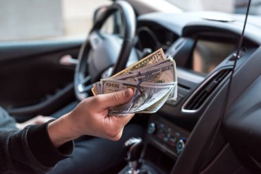 Adam arabada otururken dolar veriyor. alışveriş konsepti, para