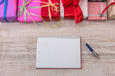 Açık not defterli renkli hediye kutuları. Yeni yıl planlaması. Yeni başlangıç