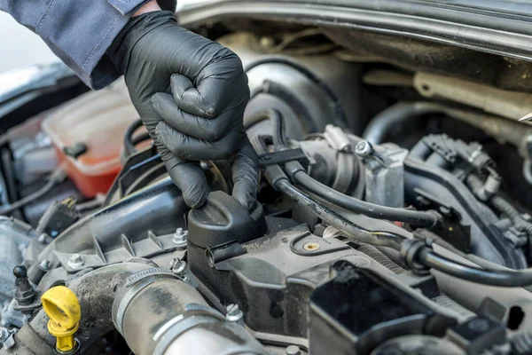 mechanic is opening the oil cap for change of oil from a car engine. auto service