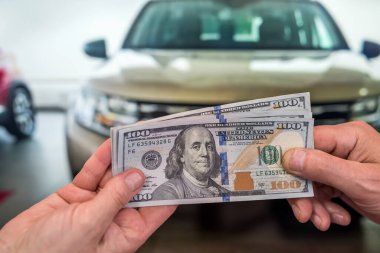 İş adamı araba alıyor ya da kiralıyor. Dolar satıyor.