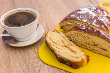 Lezzetli kahvaltı için bir dilim çörek ve pudra ile bir fincan kahve. Taze tatlı pasta.