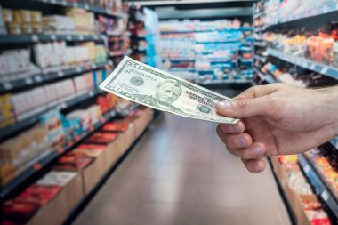 Adam süpermarkette dolar tutuyor. satın alma kavramı