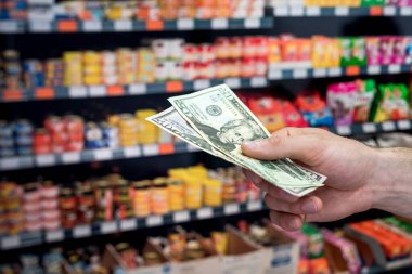 Adam süpermarkette dolar tutuyor. satın alma kavramı