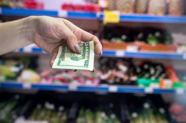 Adam süpermarkette dolar tutuyor. satın alma kavramı
