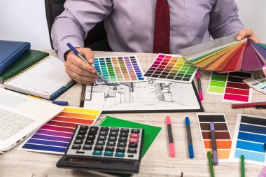 Mühendis ve mimar konsepti - Tasarımcı yaratıcı taslak planı planı ve renk örnekleyici ile çalışıyor