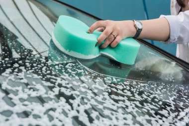 Kız arabayı köpüklü bir havluyla yıkıyor. araba temizliği