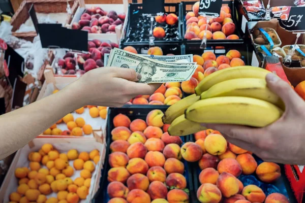 buyer giving money to the saleswoman for the fruits in supermarket. healthy lifestyle