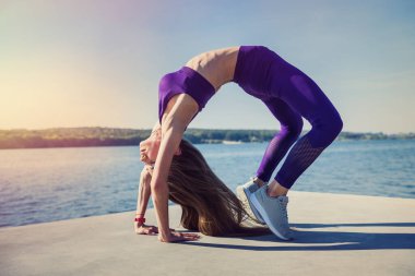 Sağlıklı bir kadın dinleniyor ve göl kenarında egzersiz yapıyor..