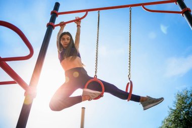 Genç, zinde kadın eğitimi gökyüzü parkında egzersiz yapıyor..