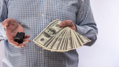 Araba anahtarı ve dolar parası olan bir iş adamı. Satış konsepti