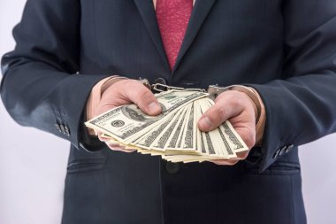 İş adamlarının elleri tutsakları dolarla kelepçeler. Yolsuzluk suçu ve rüşvet kavramı