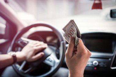 Adam arabada otururken dolar veriyor. alışveriş konsepti, para