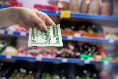 Adam süpermarkette dolar tutuyor. satın alma kavramı