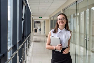 İş merkezinde duran not defterli yalnız bir iş kadını. Kahve molası