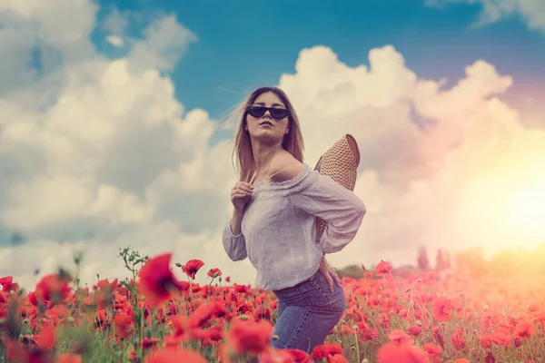 ukrainian young  lady in white blouse in the field of poppies. summer time