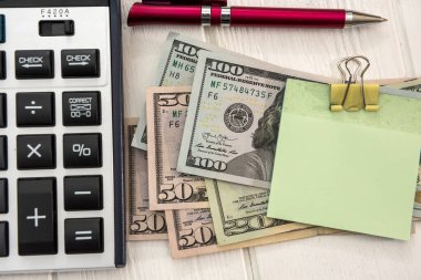 Hesap makinesi ve dolarlar üzerinde boş çıkartma olan kalem. para biriktirme kavramı