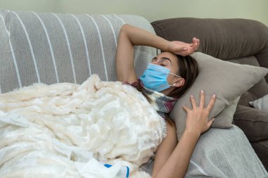 Yüksek ateşi olan, grip ya da koronavirüs virüsü kapmış 19 yaşında bir kadın battaniyeyle evde yatıyordu.  