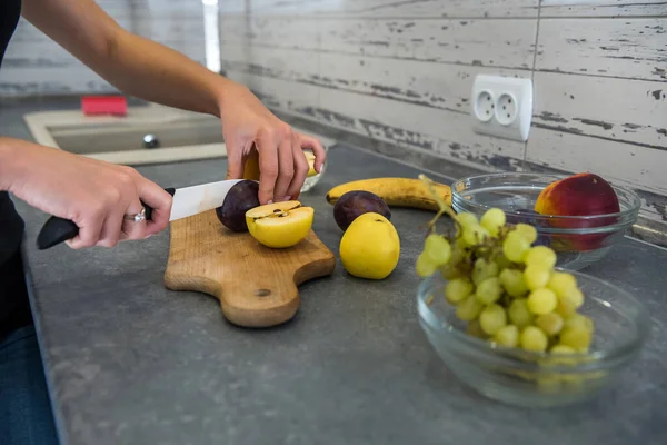 Joven Mujer Deportiva Cortando Frutas Frescas Diferentes Mesa Madera Cocina — Foto de Stock