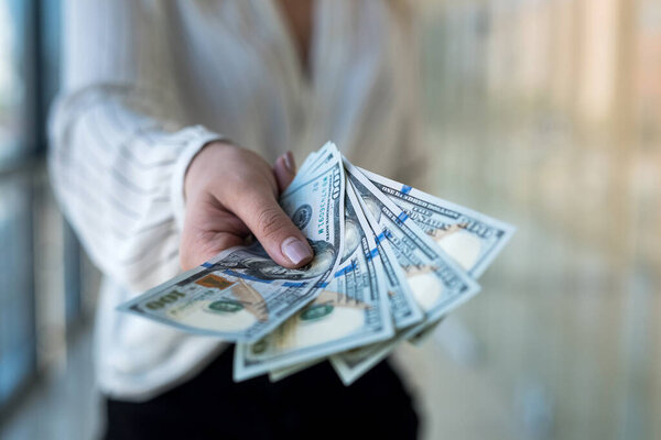 Женщина считает нам доллар в торговом центре. бизнес или покупка концепции. финансовая идея