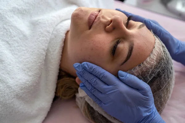 Mani Cosmetologo Guanti Azzurri Toccano Faccia Paziente Giovane Che Massaggio — Foto Stock