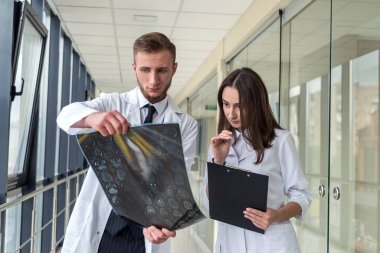 Kafa yaralanması tedavisi için beyin MR 'ına bakan iki stajyer doktor. Sağlık kavramı