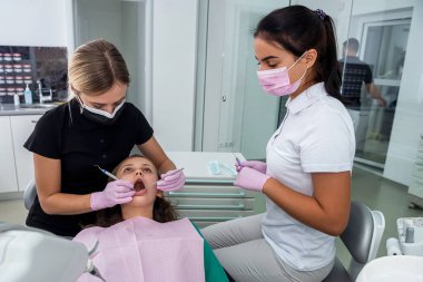 Klinikteki genç dişçide gözden geçirilen hasta. Sağlıklı diş ve ilaç konsepti