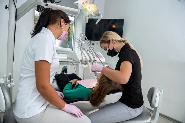 Kvindelig Tandlæge Med Assistent Undersøger Patientens Tænder Klinikken Sundhedspleje - Stock-foto