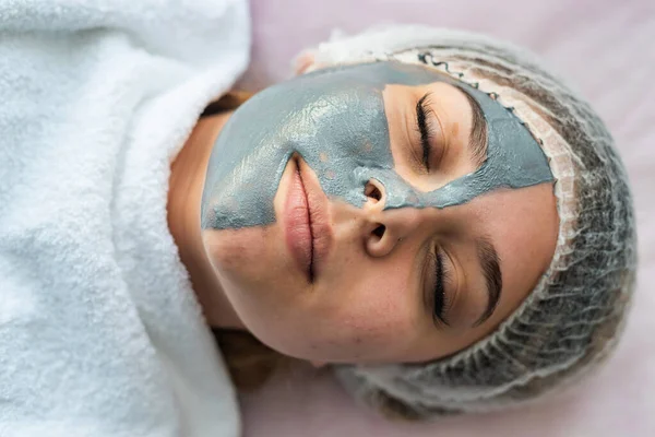 Młoda Kobieta Maską Twarzy Leżąca Łóżku Klinice Kosmetycznej Koncepcja Opieki — Zdjęcie stockowe