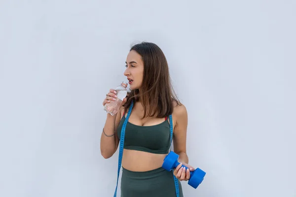 Ung Atletisk Kvinna Håller Hantel Och Flaska Vatten Över Vit — Stockfoto