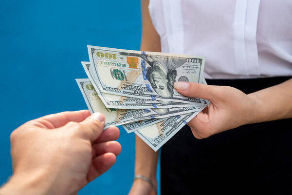 Businesswoman with dollars isolated on blue. Finance concept