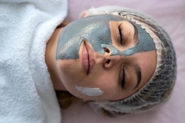 Kaplıcada dinlenen genç bir kız, yüz maskesiyle yatakta yatıyor. Kendime zaman ayırıyorum.