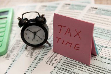 Saat kalemi ve hesap makinesi 1040 formunda. Vergi doldurma kavramı  