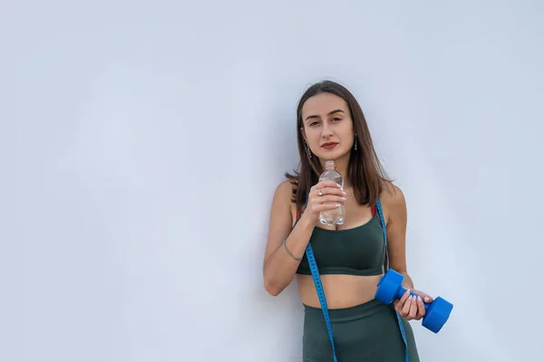 Ung Atletisk Kvinna Håller Hantel Och Flaska Vatten Över Vit — Stockfoto