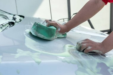 Yakından bakınca köpüklü yıkamalı yeşil sünger kullanılıyor. temizlik kavramı.