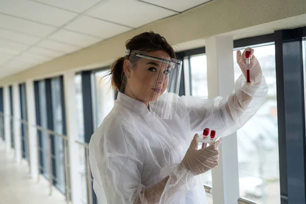 young female scientist making research with the blood sample in clinical laboratory. Coronavirus or COVID-19 concept