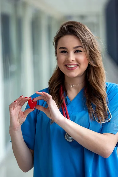 Uśmiechnij Się Piękna Pani Doktor Niebieskim Mundurze Stetoskopem Trzymającym Serce — Zdjęcie stockowe