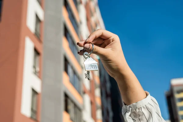 salesman handing keys in the residential area background. sale or rent concept