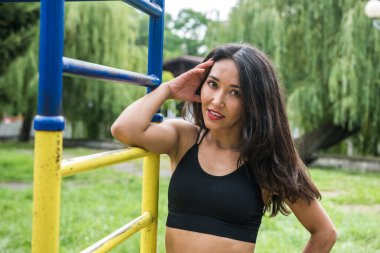 Yazın güneşli bir günde, sokak sporları sahasındaki barda egzersiz yapan genç bir bayan atlet. Sağlıklı yaşam tarzı