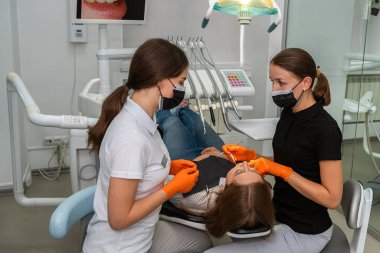 Dişçi dişçi muayenehanesinde hasta ameliyatı yapıyor. sağlık hizmeti kavramı