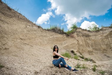 Kadın kum dağının arka planında poz veriyor, yaz yaşam tarzı, doğanın güzelliği.