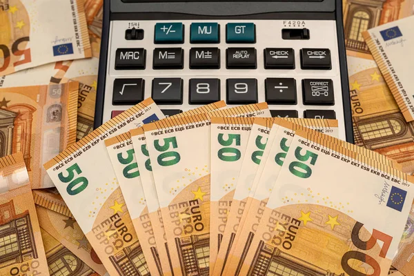 ユーロの現金と計算機の山を背景に — ストック写真