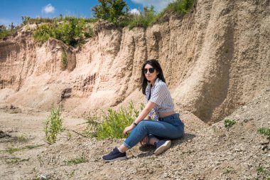 Kum ocağının önünde duran zayıf bir kadının portresi. Yaz yaşam tarzı, özgürlük.